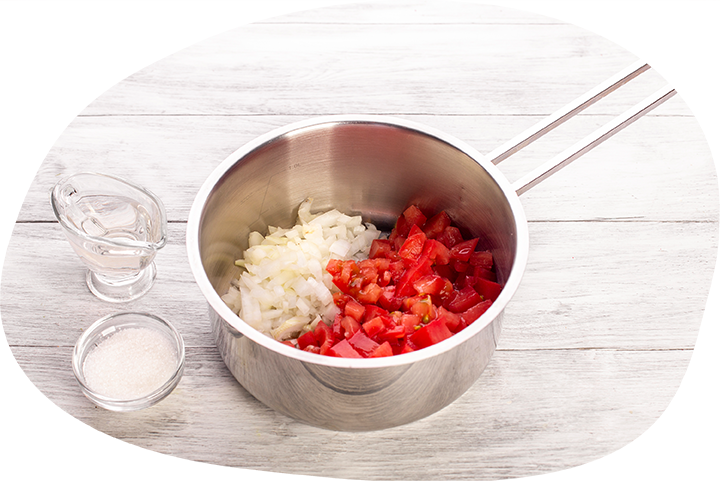 Приготовьте кетчуп. В сотейник поместите мелко нарезанные помидоры, измельченный лук, сахар и уксус. Тушите на небольшом огне 30 минут, помешивая.