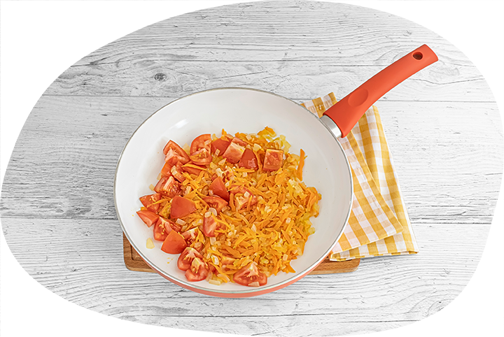 3.	Разогрейте в большой сковороде масло и обжарьте лук до мягкости, добавьте морковь и жарьте еще 5 минут. Выложите помидоры и готовьте все вместе 10 минут.
